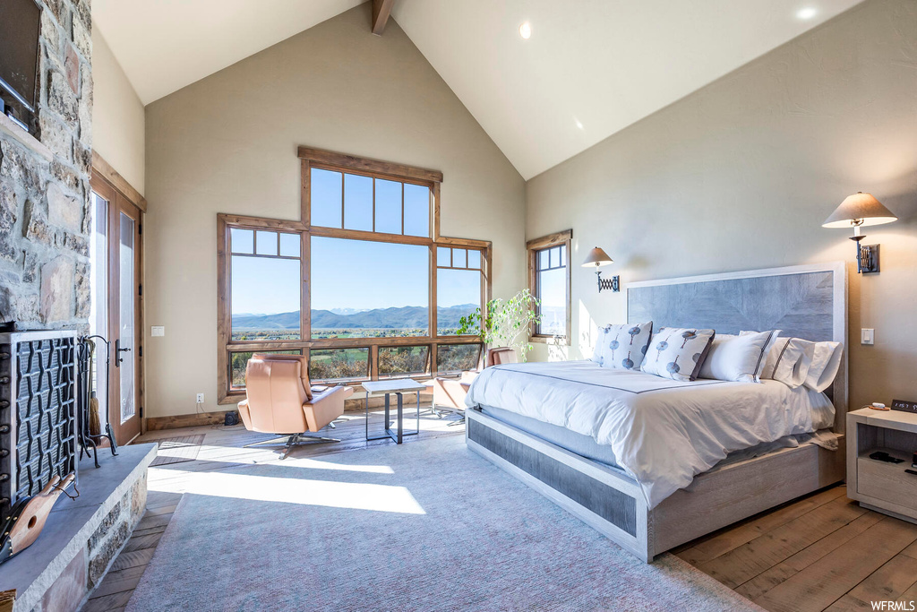 Bedroom featuring high vaulted ceiling, a mountain view, beam ceiling, and light hardwood / wood-style flooring
