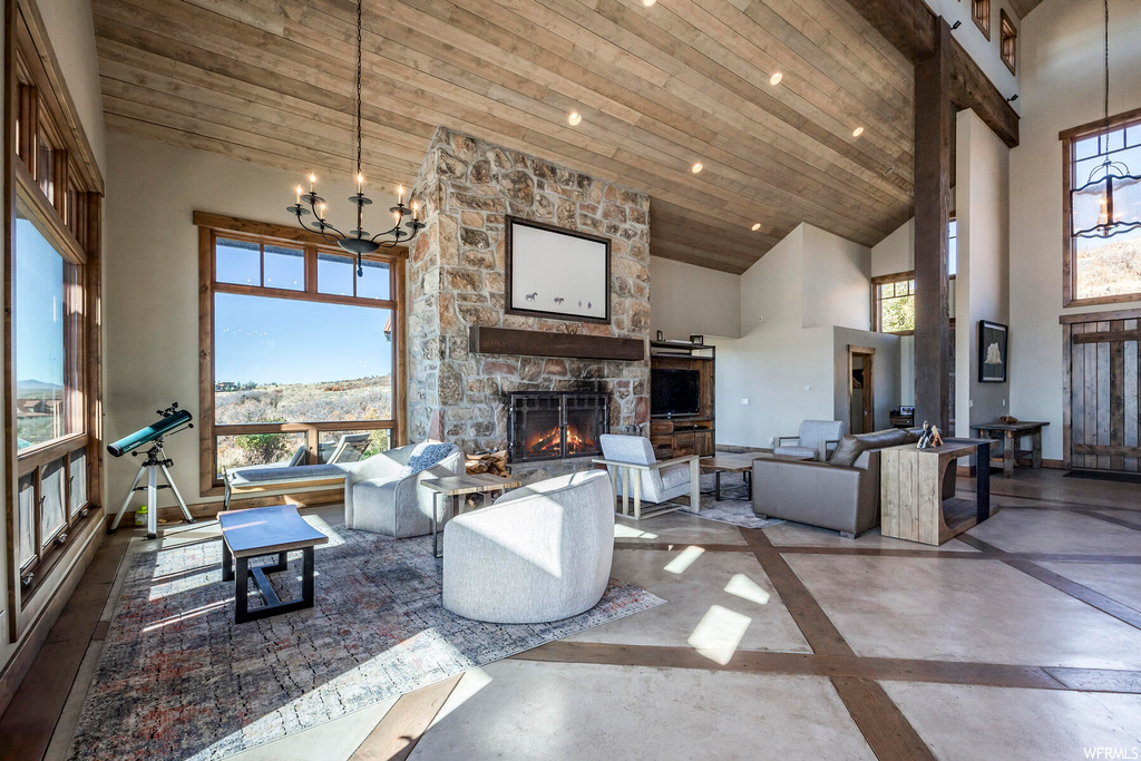 Living room featuring plenty of natural light, wood ceiling, high vaulted ceiling, and a notable chandelier