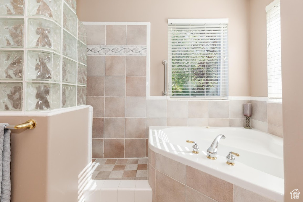 Bathroom with tile walls and tiled tub