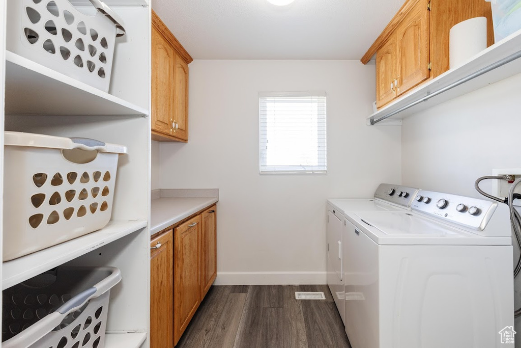 Laundry area with washer hookup, cabinets, dark hardwood / wood-style floors, and washer and clothes dryer