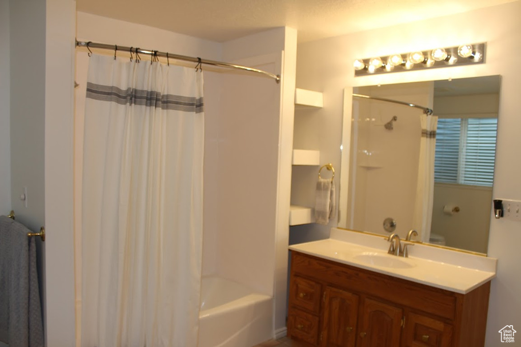 Bathroom with shower / bath combo with shower curtain and vanity with extensive cabinet space