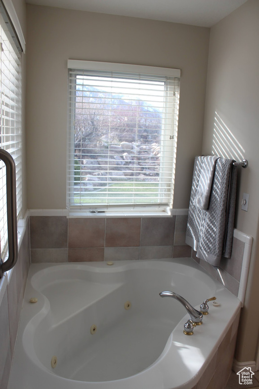 Bathroom featuring a wealth of natural light and tiled tub
