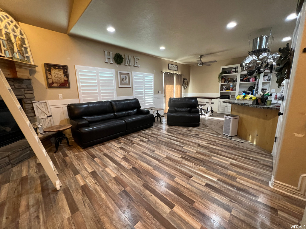 Living room featuring wood-type flooring and ceiling fan
