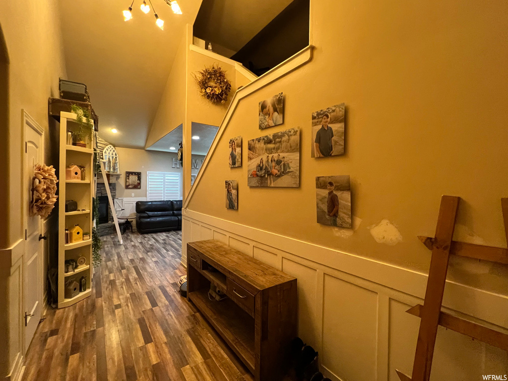 Hallway with vaulted ceiling and dark hardwood / wood-style flooring