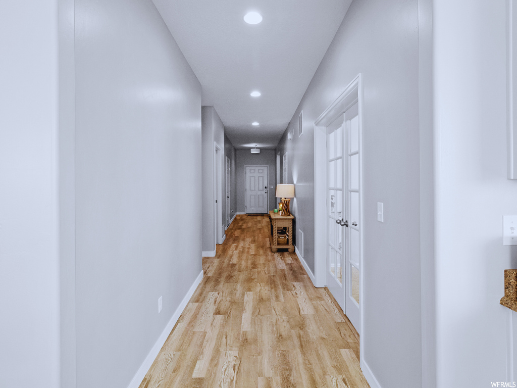 Hall with french doors and light hardwood / wood-style flooring