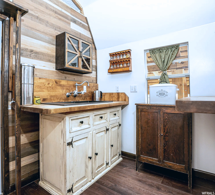 Kitchen with wood walls and dark hardwood flooring