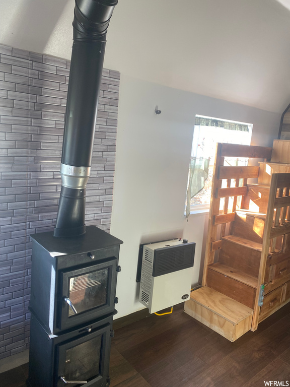 Details featuring a wood stove and dark hardwood / wood-style floors