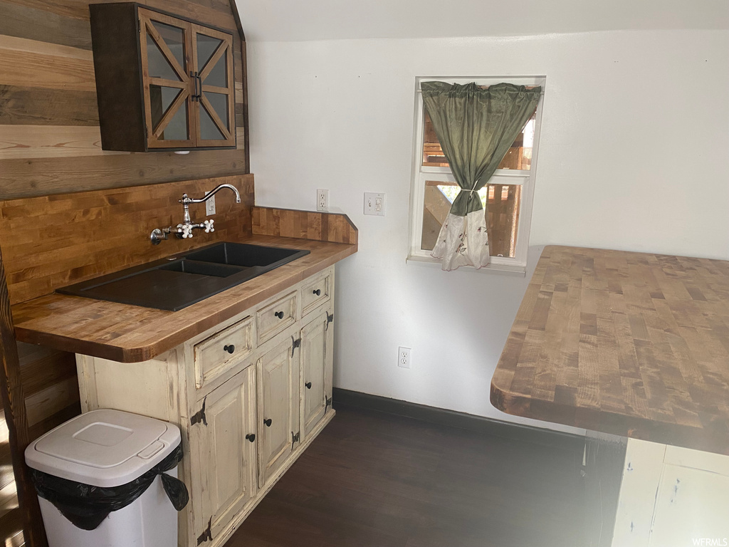 Kitchen with sink, wooden counters, and dark hardwood / wood-style floors