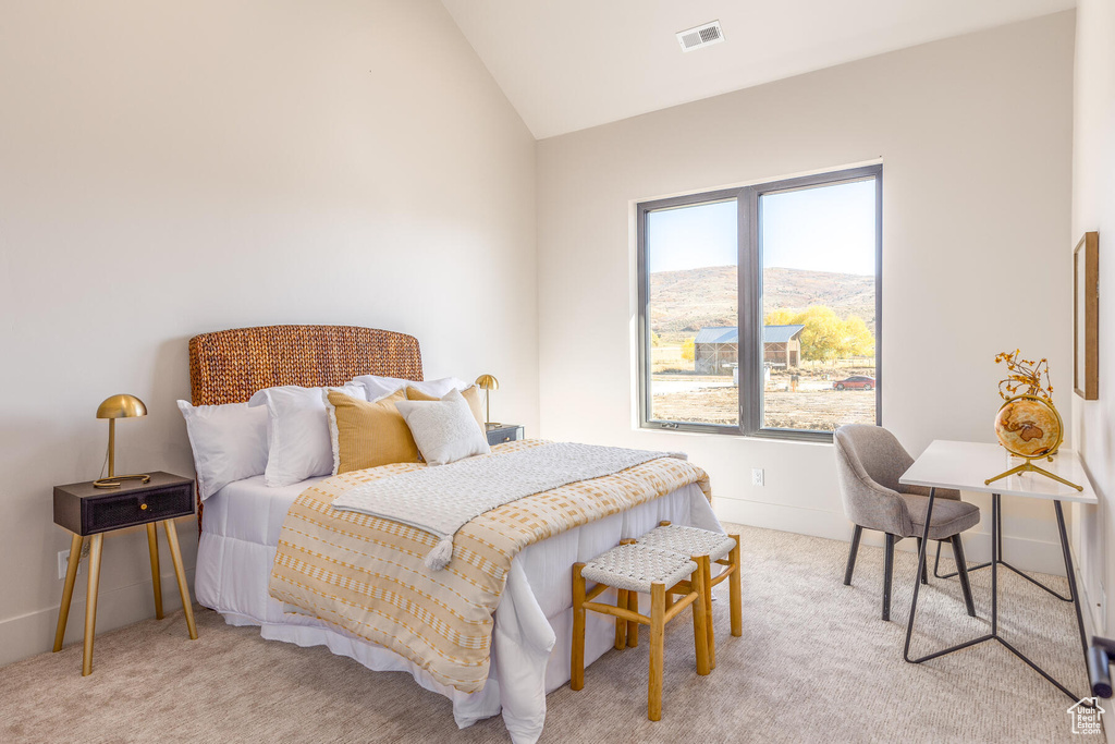 Carpeted bedroom with vaulted ceiling and a mountain view