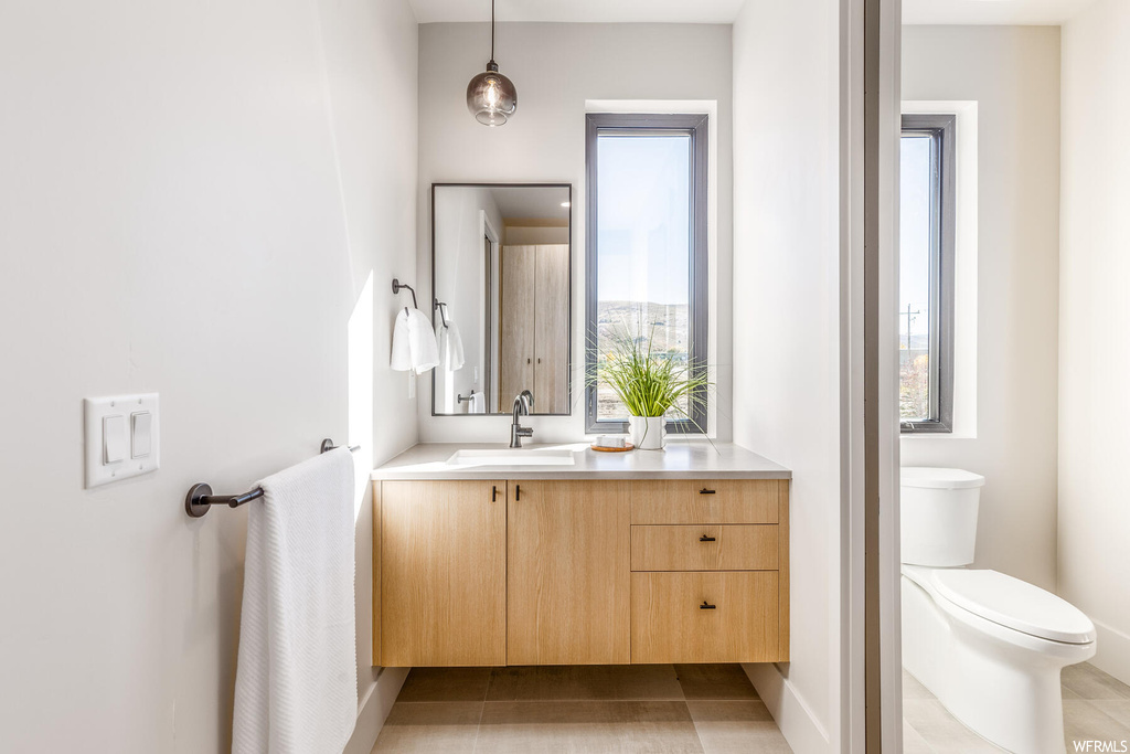 Bathroom with a wealth of natural light, oversized vanity, and tile floors