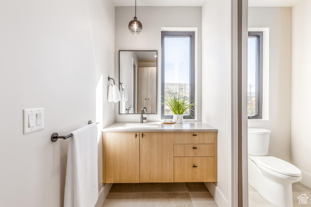 Bathroom featuring vanity, toilet, and tile patterned floors