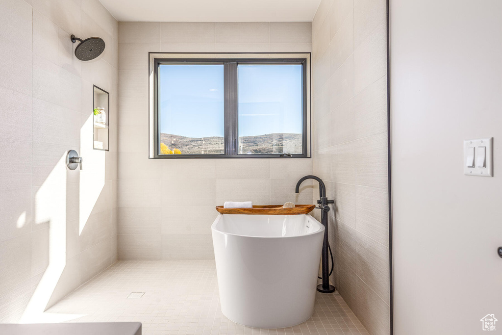 Bathroom featuring tile walls, tile patterned flooring, and separate shower and tub