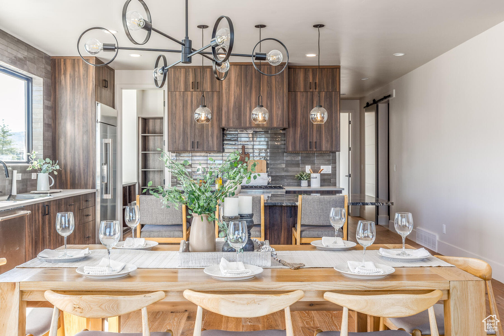 Kitchen with a barn door, backsplash, high quality fridge, and a breakfast bar