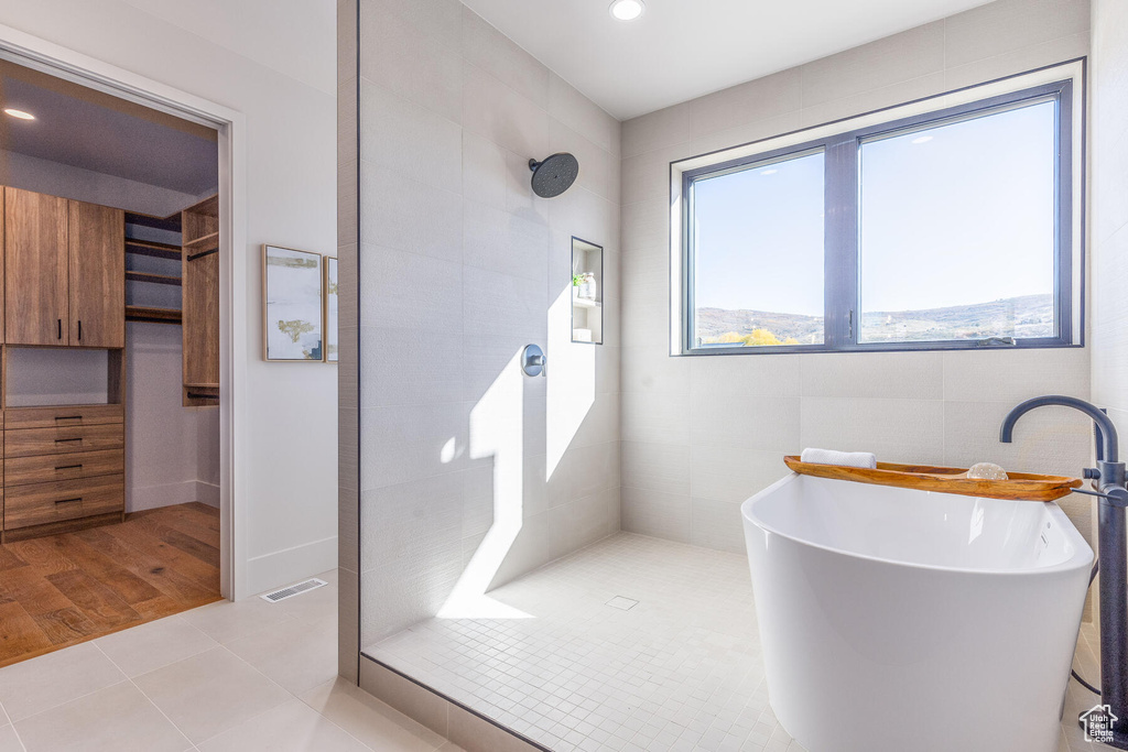 Bathroom featuring independent shower and bath, sink, and hardwood / wood-style floors