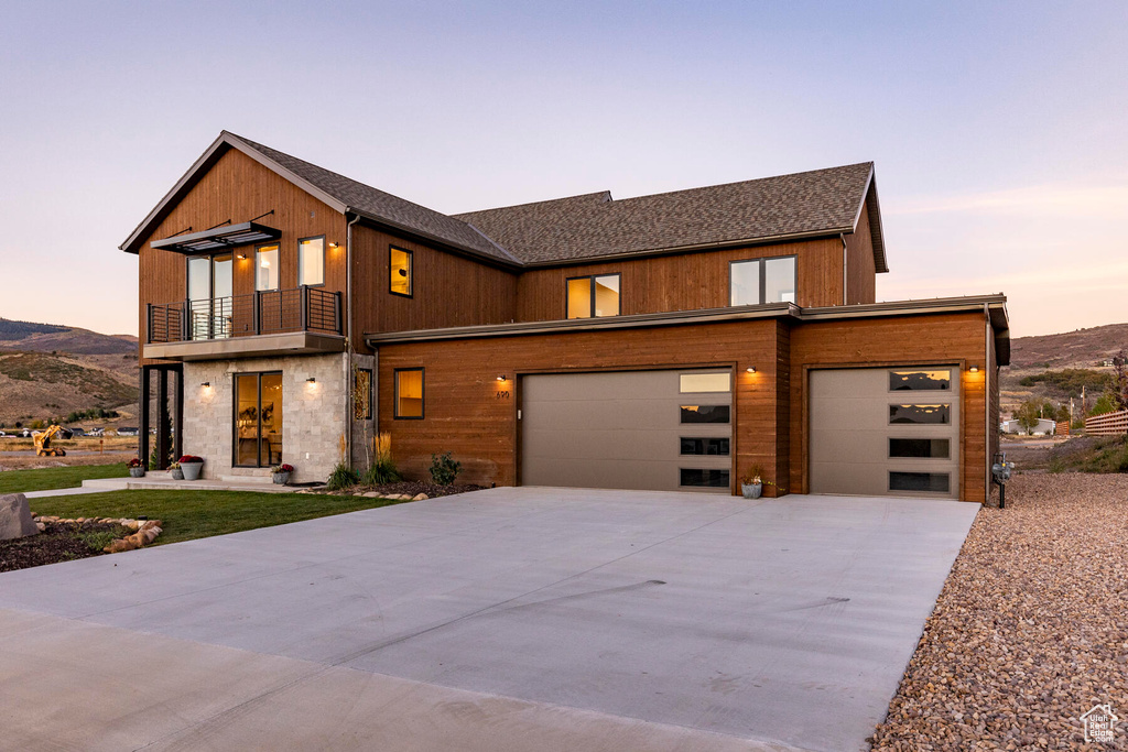 View of front of property featuring a balcony, a garage, and a mountain view