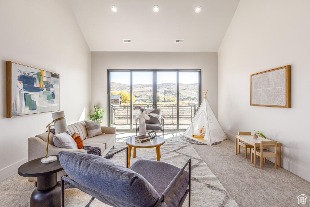 Living room featuring light carpet, a mountain view, and high vaulted ceiling