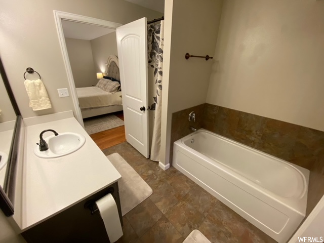 Bathroom featuring a bathing tub, vanity, and tile floors