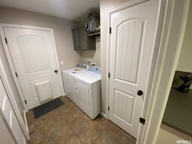 Washroom with washer and dryer, washer hookup, light tile floors, and cabinets