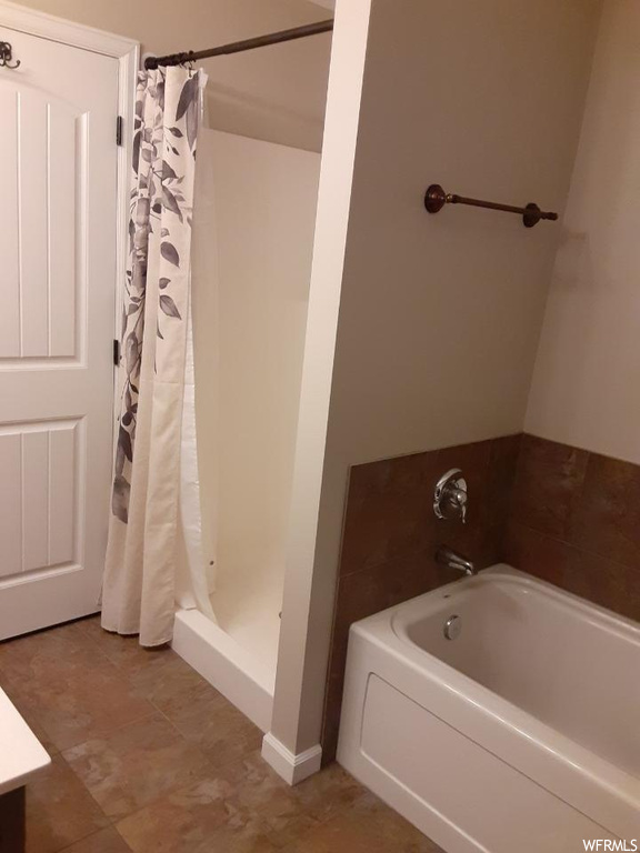 Bathroom featuring a shower with shower curtain, tile floors, and vanity