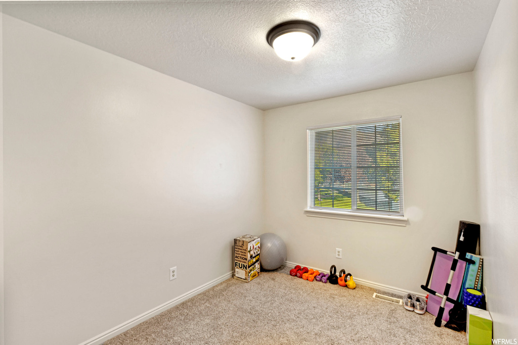 Playroom with light carpet and a textured ceiling