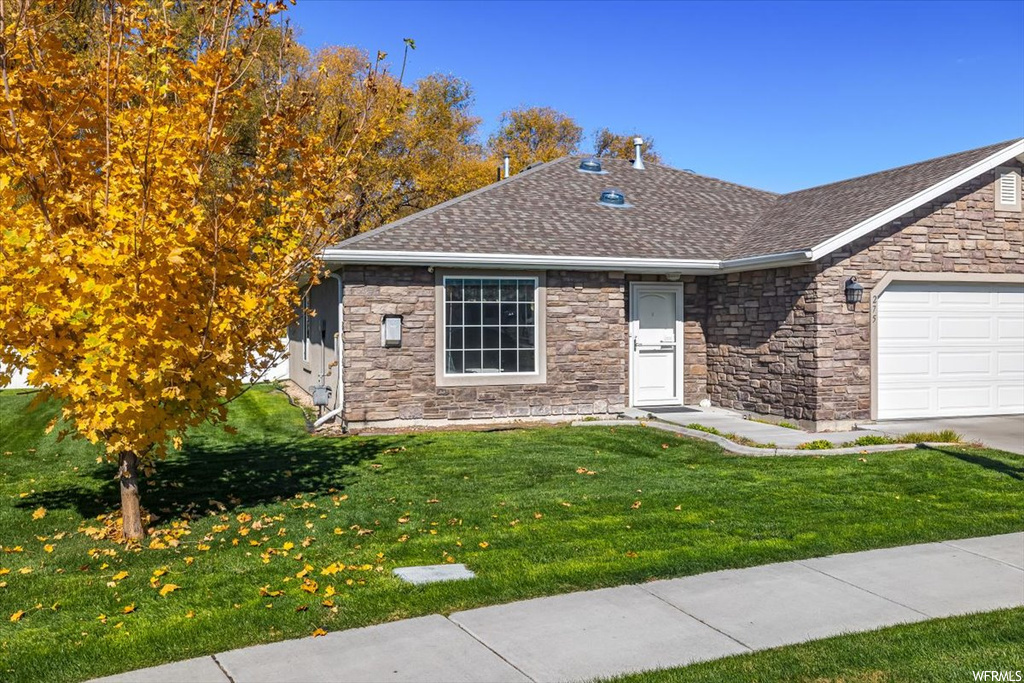 View of front of home featuring a garage and a front lawn