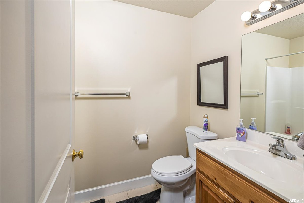 Bathroom with tile flooring, vanity, and toilet