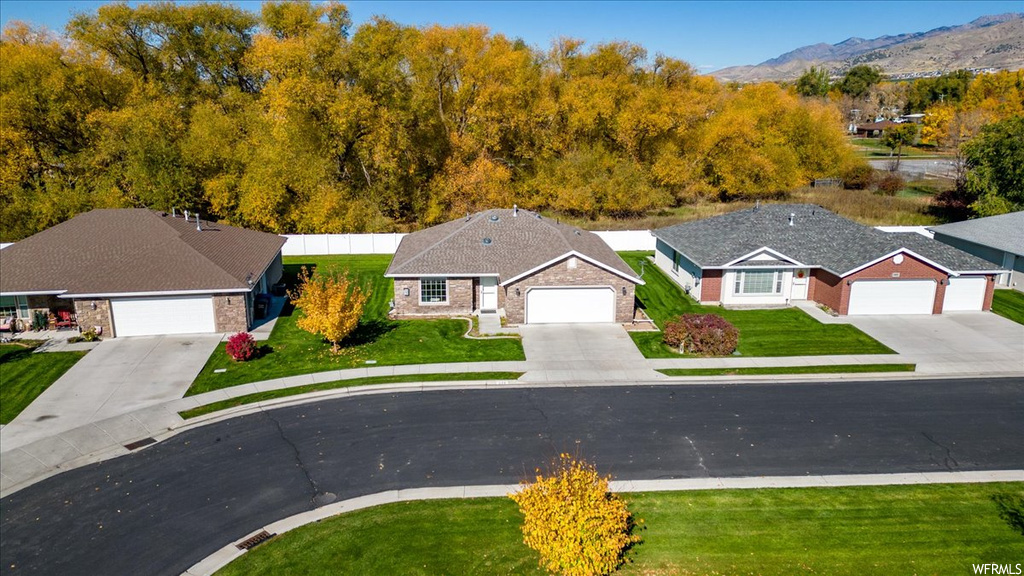 View of front facade featuring a front yard, a garage, and a mountain view