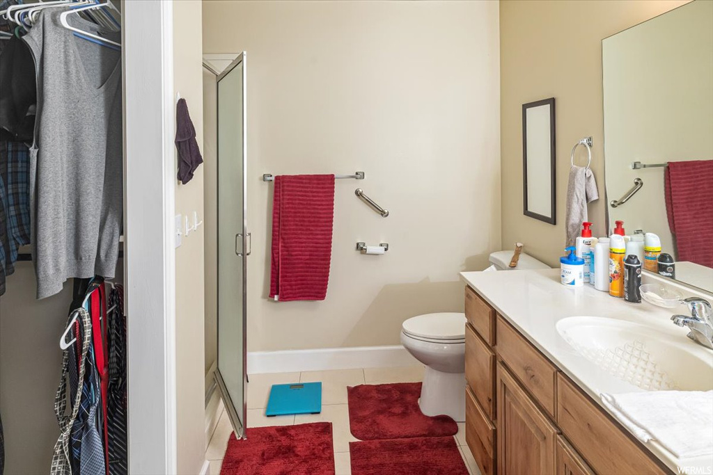 Bathroom featuring tile floors, toilet, an enclosed shower, and oversized vanity