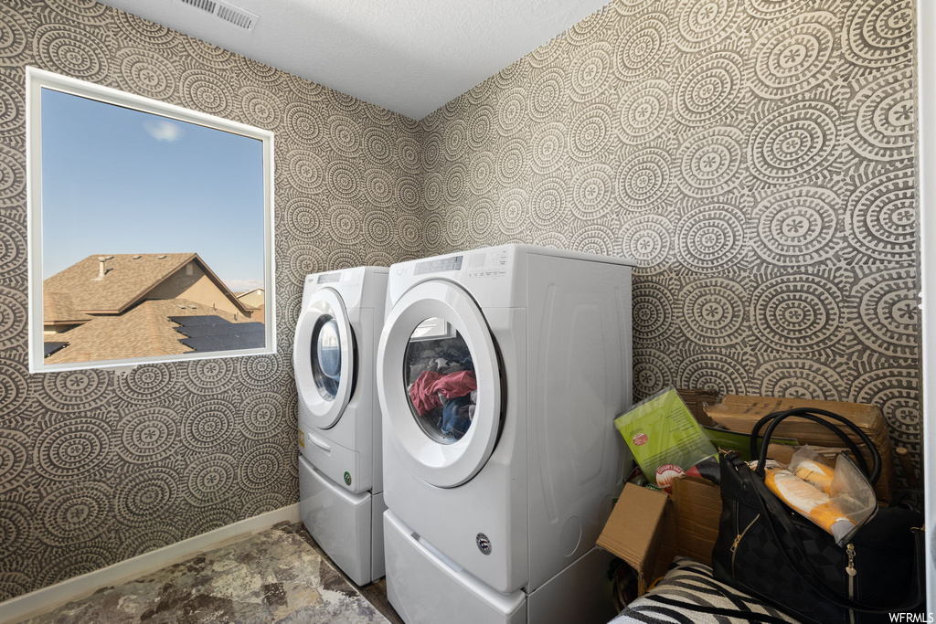 Laundry room featuring washing machine and clothes dryer and light tile floors