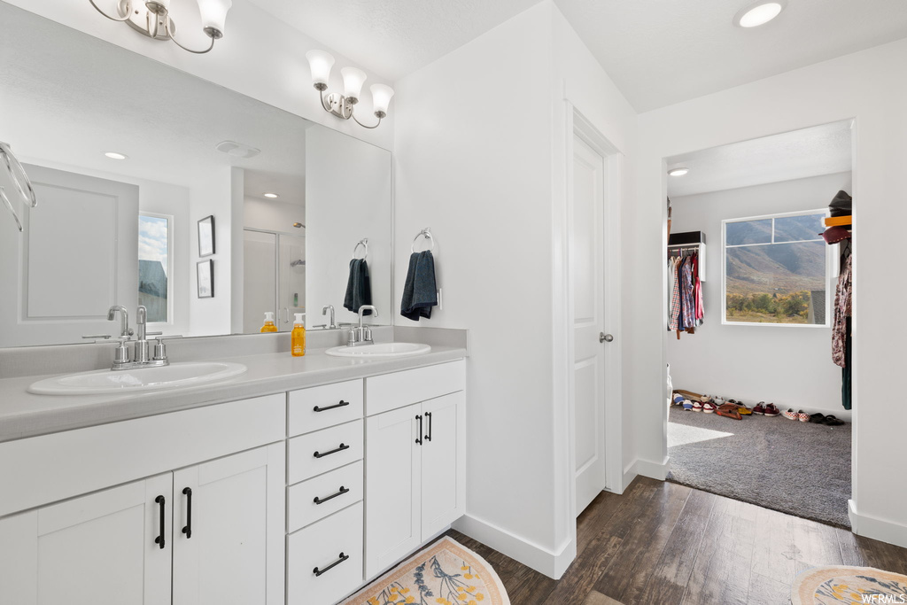 Bathroom with plenty of natural light, double sink vanity, and hardwood / wood-style flooring