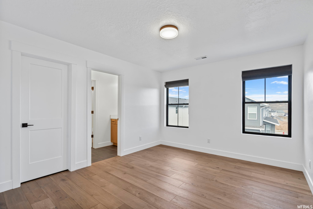 Empty room featuring plenty of natural light and hardwood / wood-style flooring