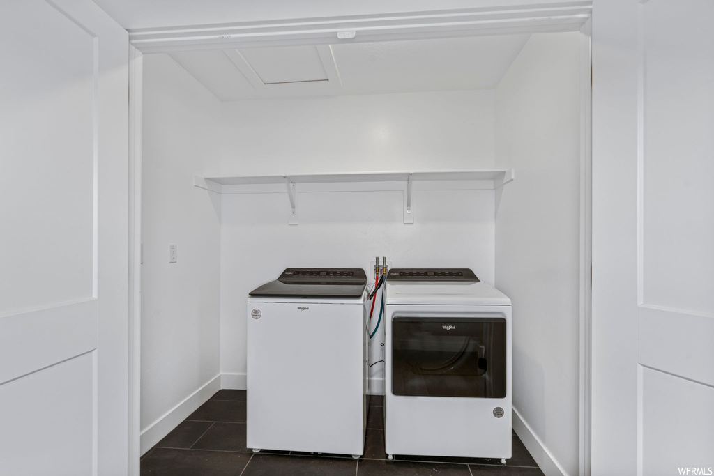 Laundry room featuring washing machine and clothes dryer and dark tile floors
