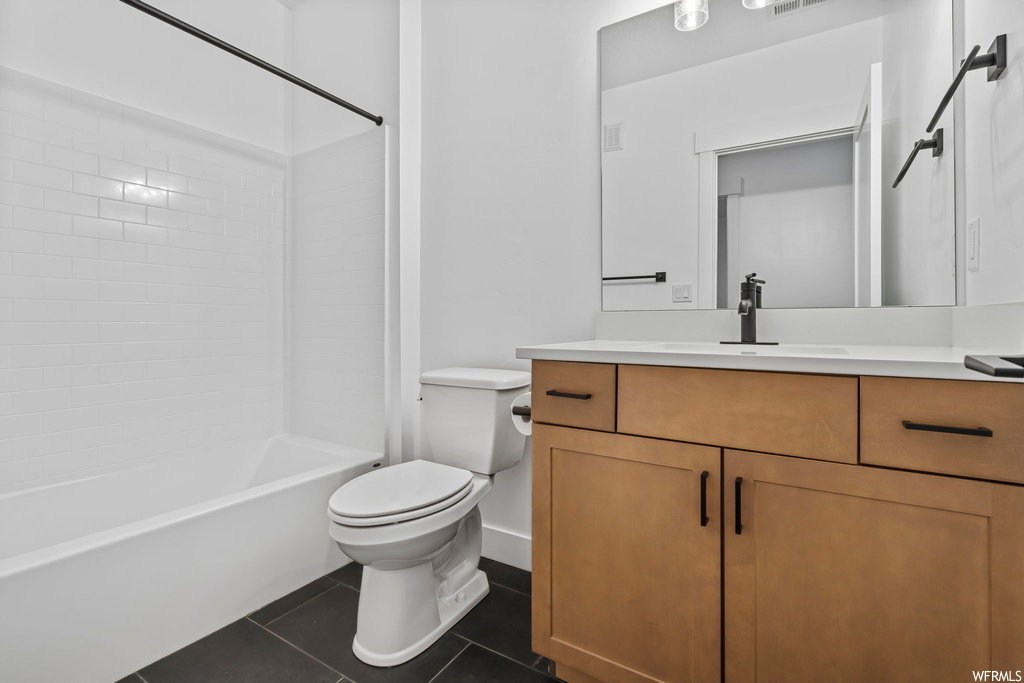 Full bathroom featuring shower / bath combination, tile floors, vanity, and toilet