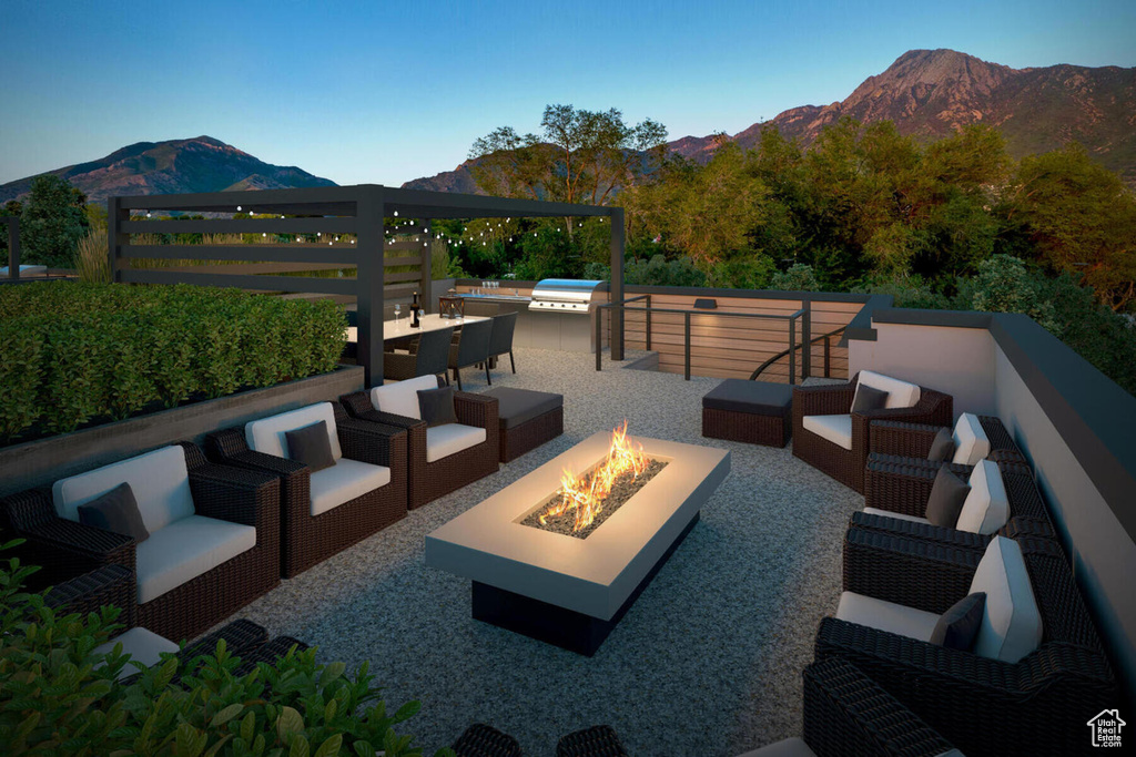 View of patio featuring a mountain view and an outdoor living space with a fire pit