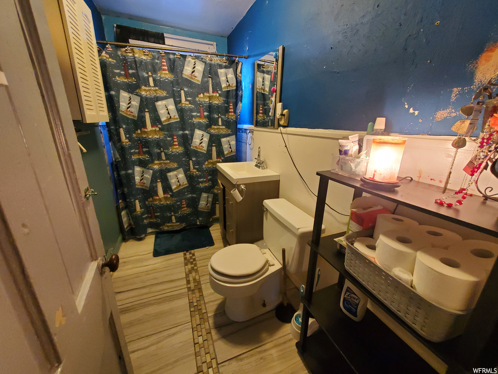 Bathroom with vanity, hardwood / wood-style floors, and toilet
