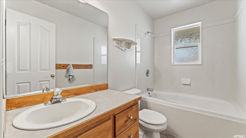 Full bathroom featuring toilet, oversized vanity, and shower / bathing tub combination