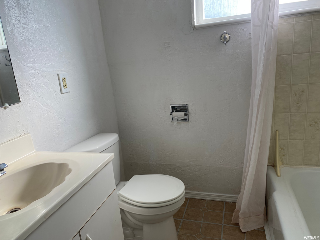 Full bathroom featuring vanity, tile flooring, shower / tub combo, and toilet