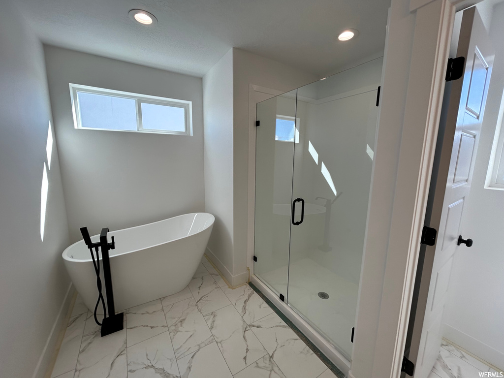 Bathroom with plenty of natural light, tile floors, and separate shower and tub