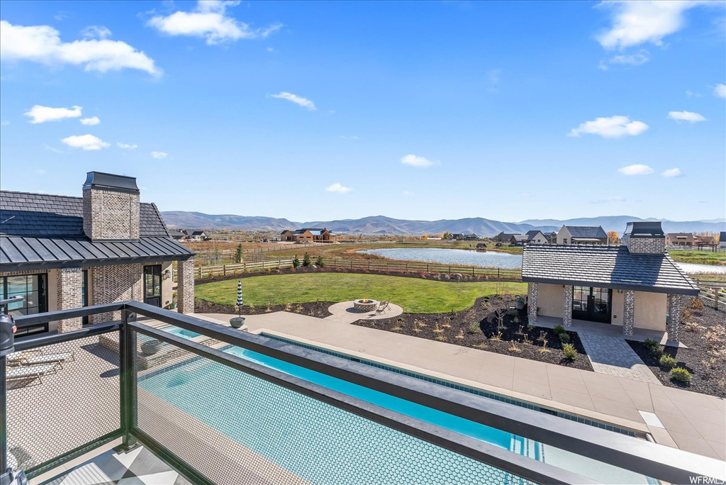View of pool with a yard and a mountain view