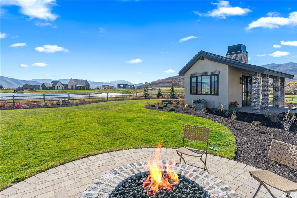 View of yard with a fire pit, a mountain view, and a patio