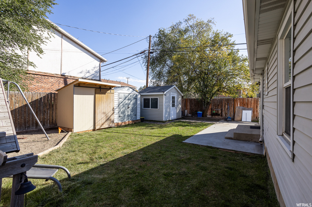 View of yard featuring a storage shed and a patio area