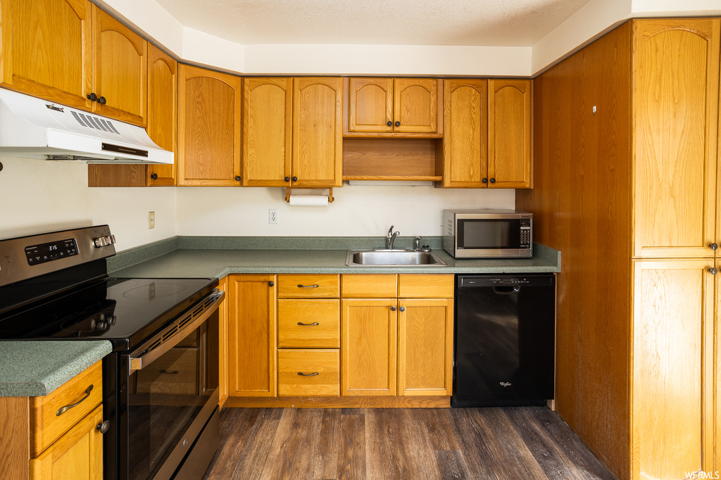 Kitchen featuring stainless steel appliances, dark hardwood / wood-style flooring, and sink