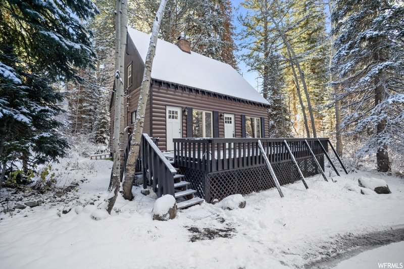 Snow covered property featuring a wooden deck