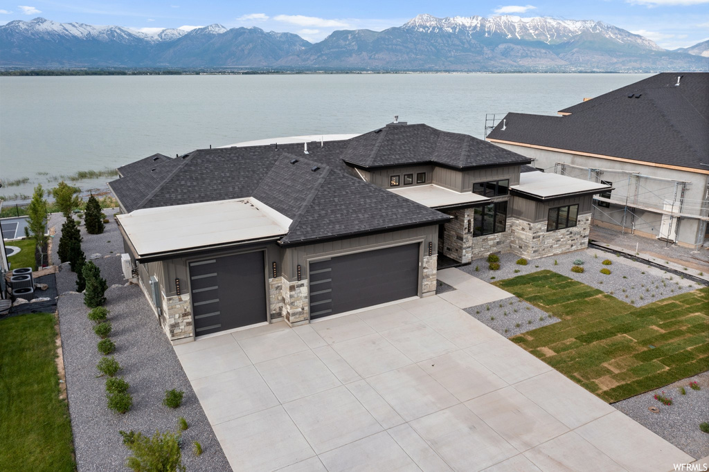 View of front of house with a garage and a water and mountain view