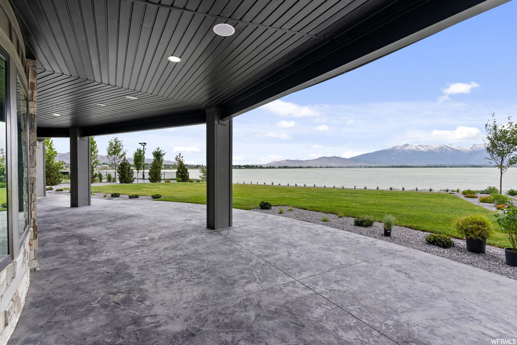 View of patio / terrace featuring a water and mountain view