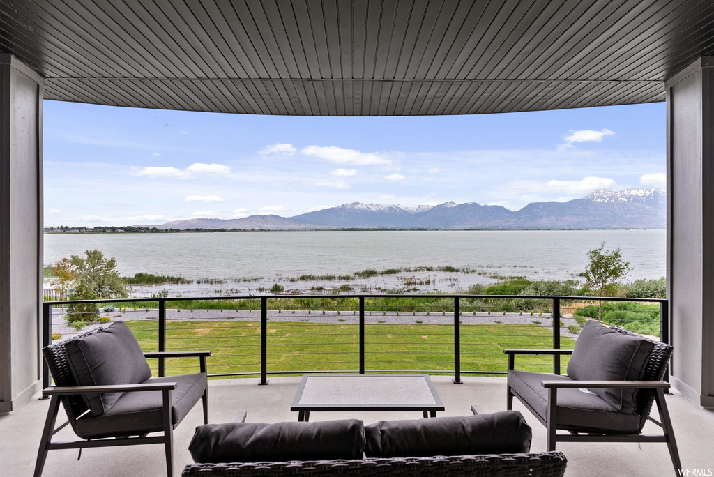 Balcony featuring a water and mountain view and outdoor lounge area