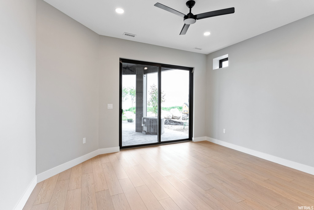 Empty room featuring plenty of natural light, ceiling fan, and light hardwood / wood-style floors