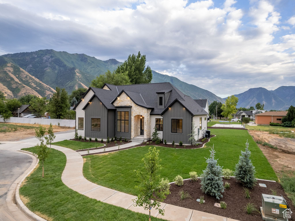 Modern inspired farmhouse featuring a mountain view and a front lawn