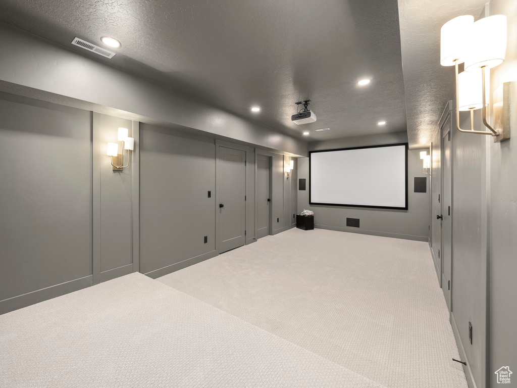 Cinema with a textured ceiling and light colored carpet