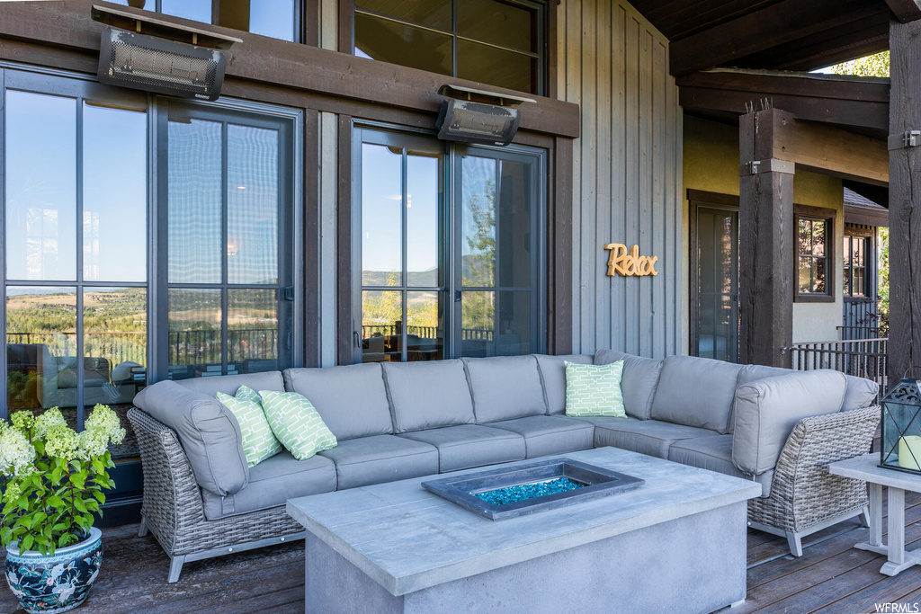 View of patio featuring an outdoor living space with a fire pit and a deck